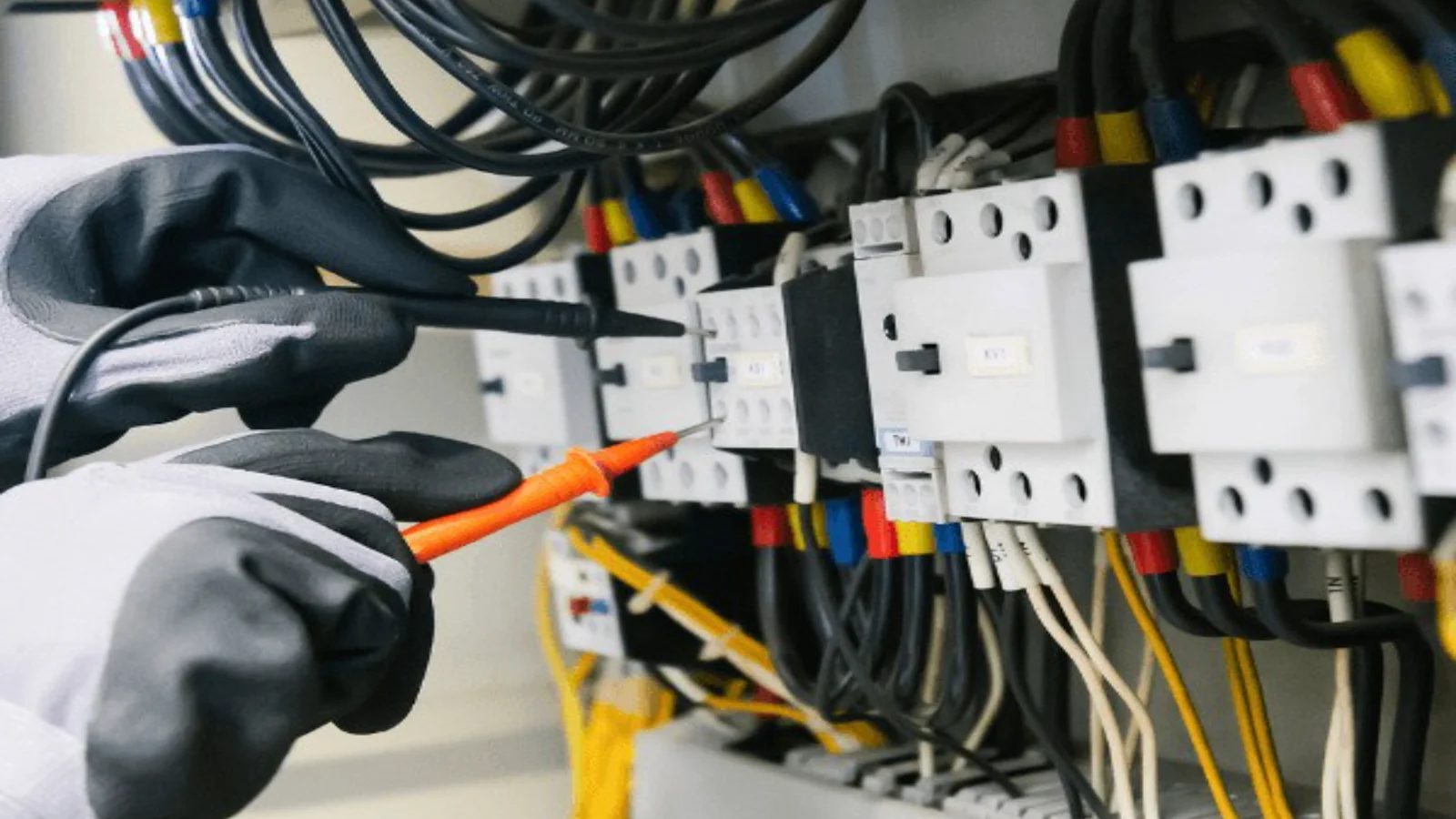 Electrician testing wiring inside a DB board
